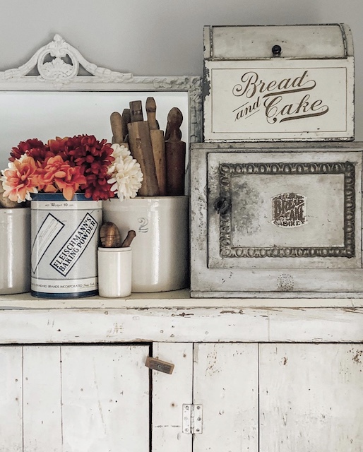 The top of an antique white cupboard styled for fall.