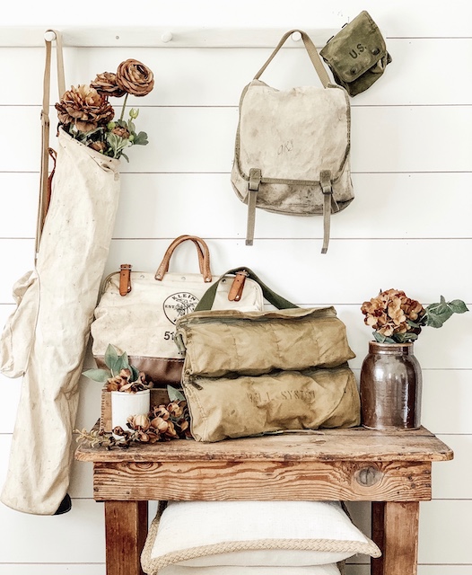 Vintage canvas bags as fall decor stuffed with flowers.