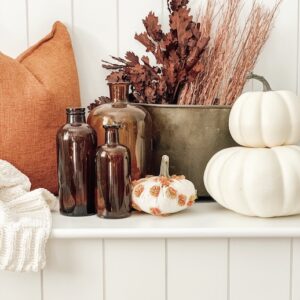 A whole lot of fall items sitting on a bench in a living room