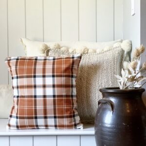A fall pillow sitting on a bench as decor
