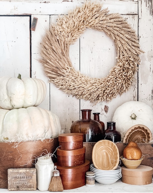 A big bunch of antique items sitting on a white table for fall.