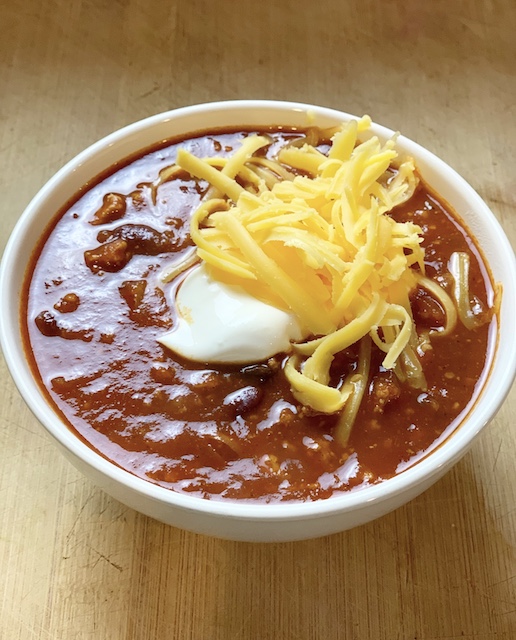 a nice warm bowl of chili sitting on a counter
