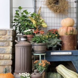 a front porch scene filled with fall items.