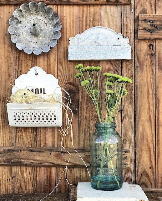 Antiques nailed to the door with flowers beside them for fall