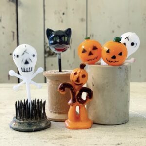 several vintage halloween cupcake toppers in a little crock
