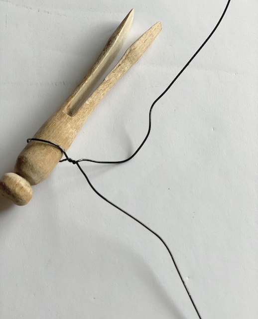 an old clothespin with wire wrapped around it.