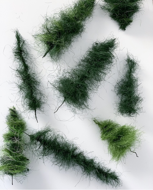 a whole bunch of bottle brush trees laid out on a table top sideways