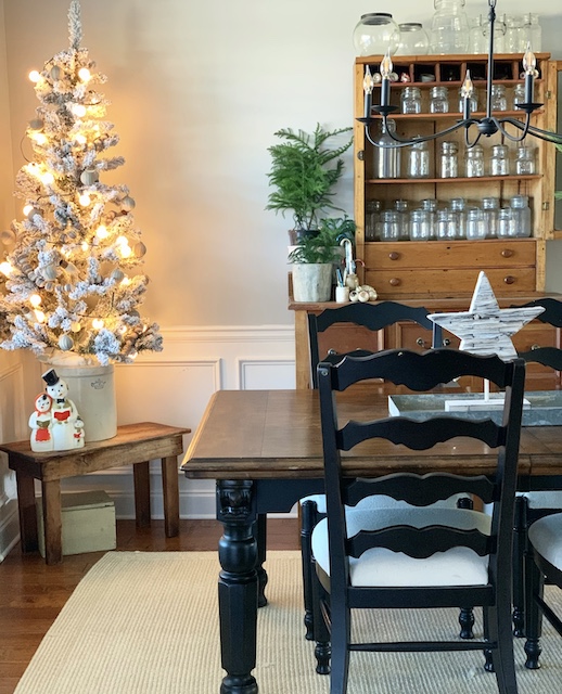 a diningroom view featuring a flocked tree 