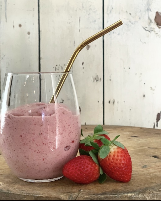 strawberries leaning against a glass