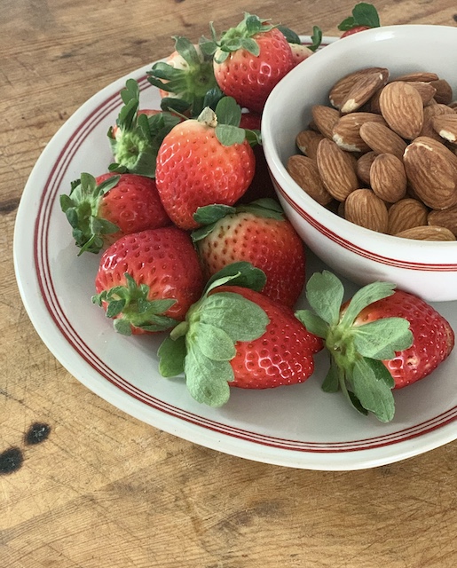 strawberries and almonds together on a plate at a different angle