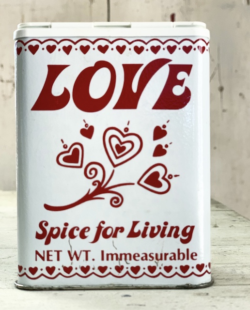 an old tin spice can with the word love on it