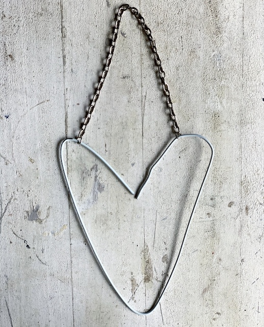 a wire heart with a. chain attached