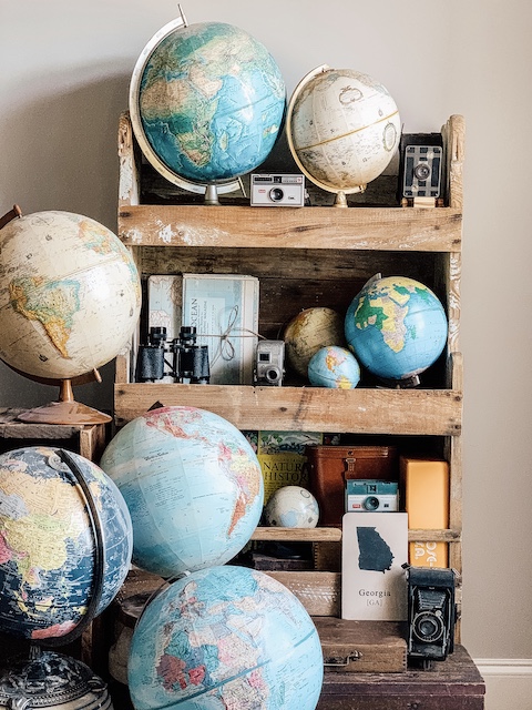 a shelf full of old books and globes