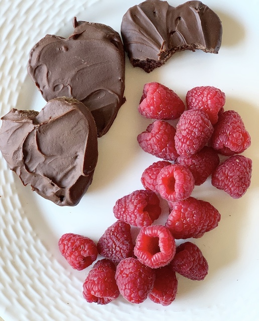 a plate with some cookies on it and some raspberries