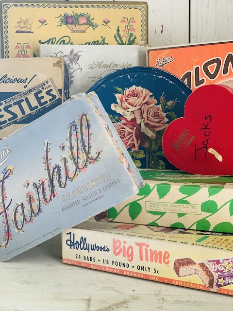 a pile of old vintage candy boxes