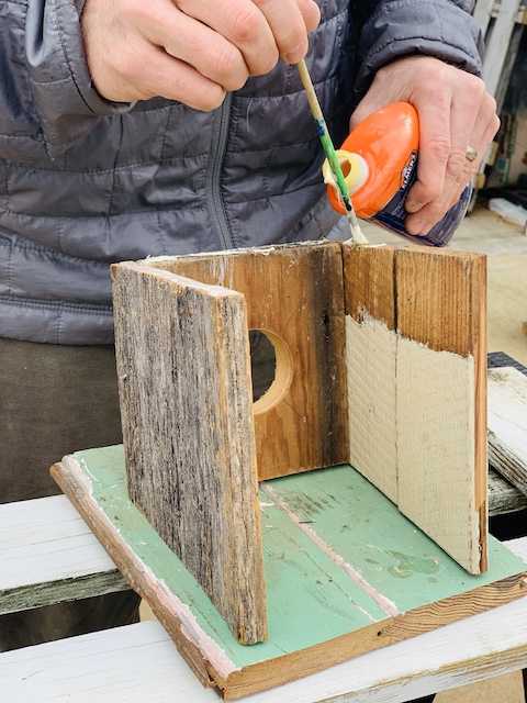 adding wood glue to the top of the birdhouse