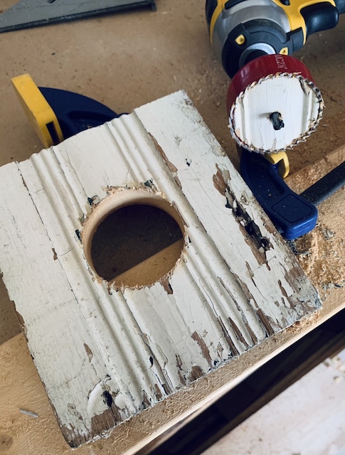 a hole cut out of a piece of wood for the birdhouse