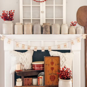 a mantle in a livingroom filled with valentine decor