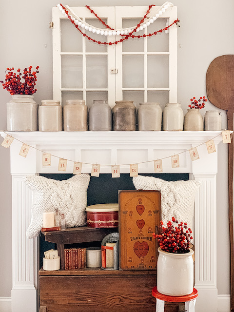 a mantle in a livingroom filled with valentine decor