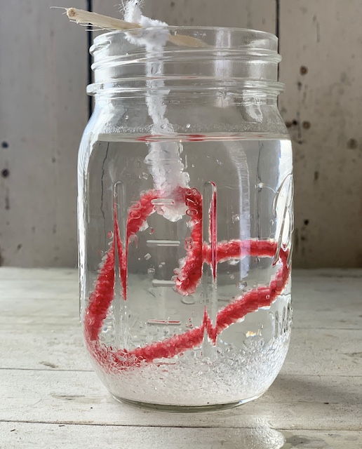 A borax crystal heart in a jar