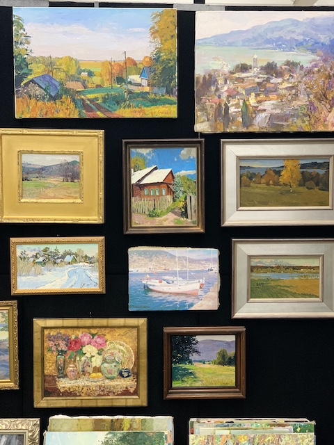a wall full of oil paintings