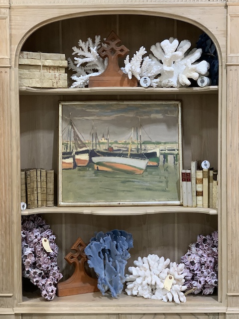 a shelf full of art and coral at an antique flea market