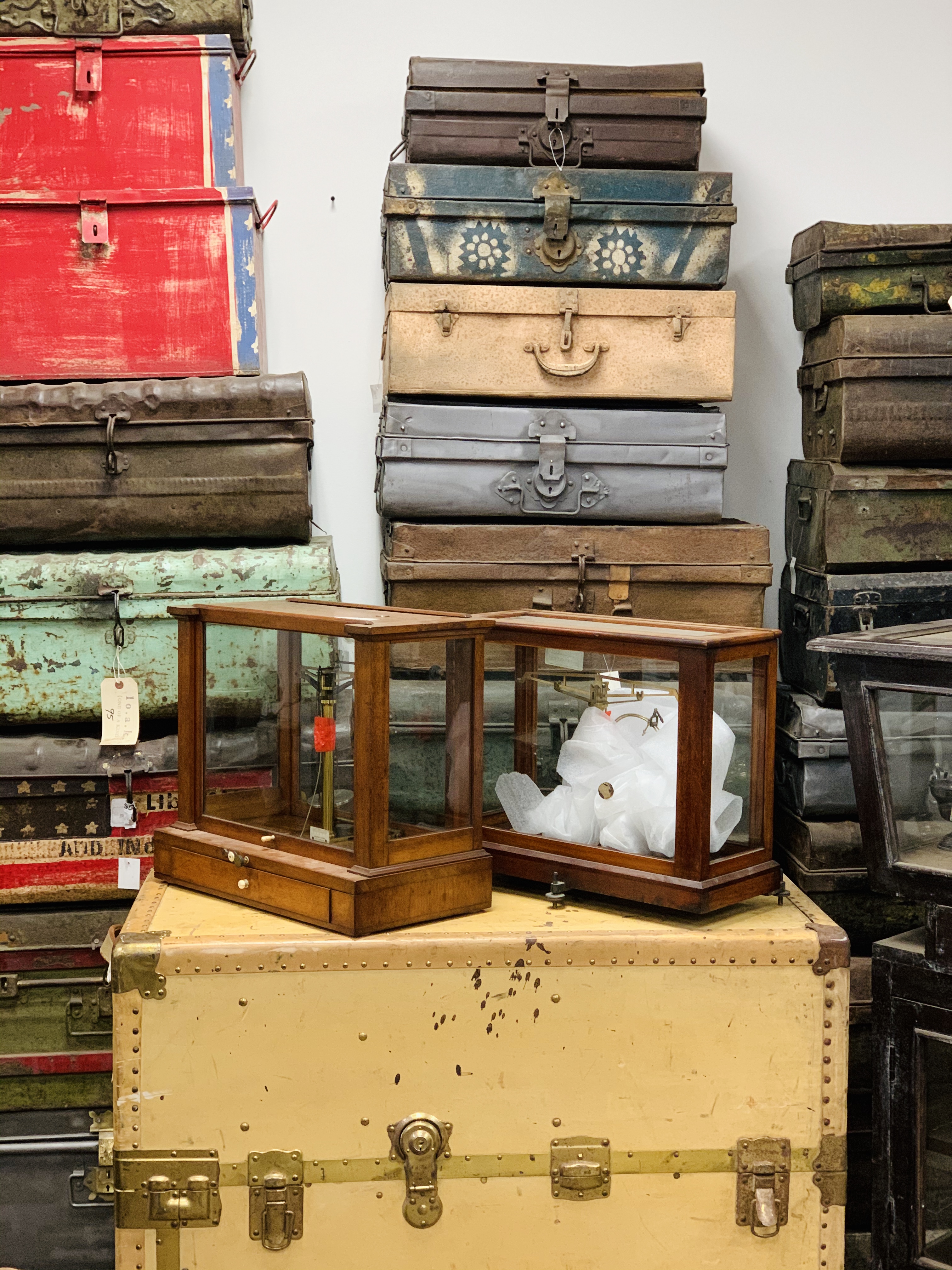 baskets and suitcases piled high at an antique flea market