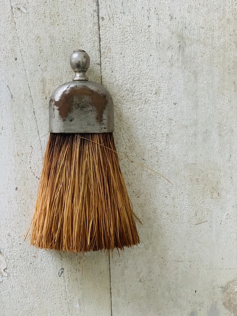 whisk broom with a silver cap