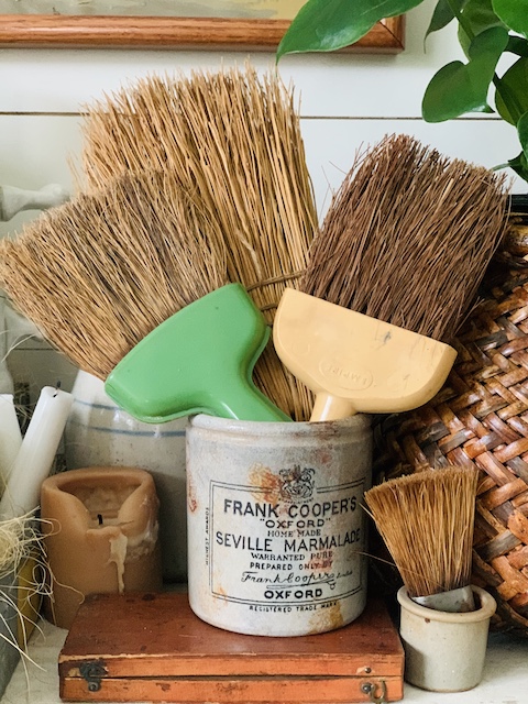 old whisk brooms in a crock