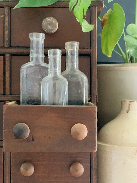 close up of some bottles in my simple summer farmhouse mantel