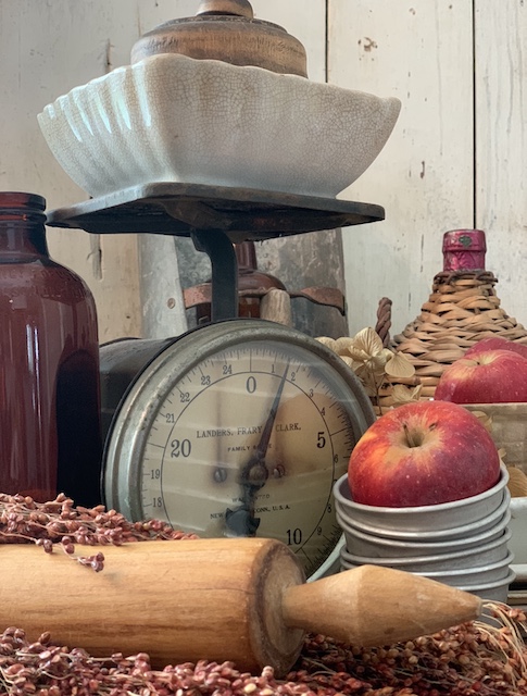 a scale with a bowl and apples and rolling pins