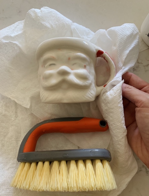 santa mug and a scrub brush sitting on a paper towel