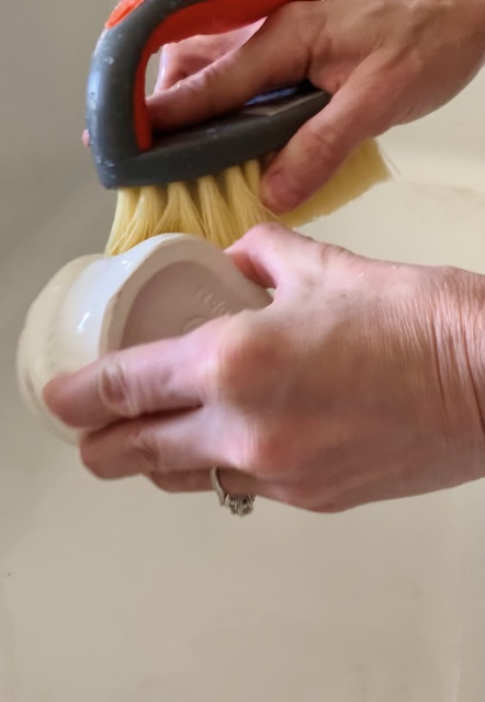 scrubbing mug with a brush under water