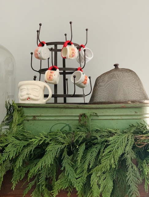 vintage santa mugs on top of kitchen cabinet