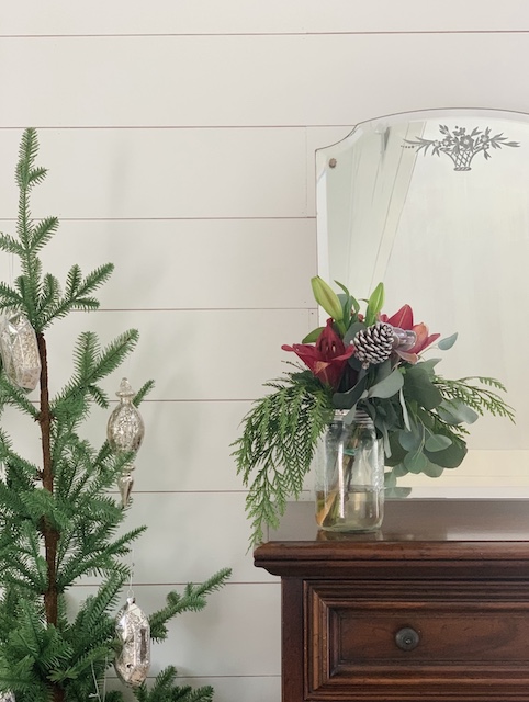 a faux tree to the left of a dresser