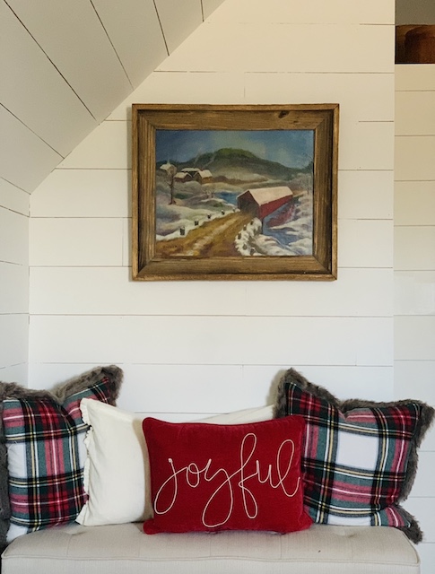 a nook in the bonus room with pillows and a painting