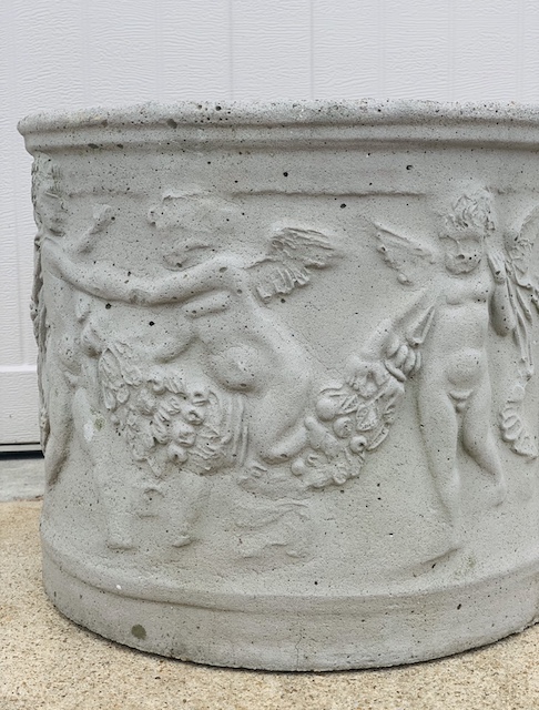 a concret planter with cupids on it