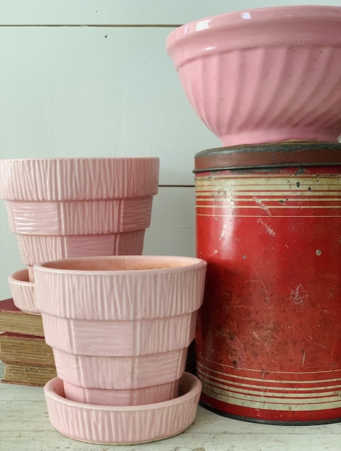 pink planters a pink bowl and a red tin