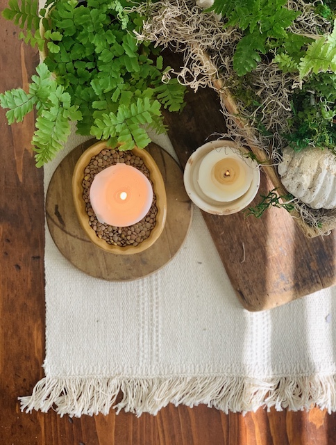 layers on the table of the carpet, board, doughbowl, candles and ferns