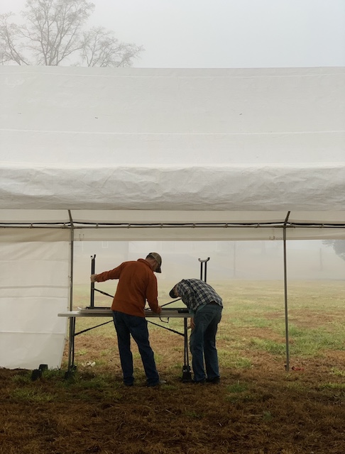 my dad and my husband setting up tables under the tent