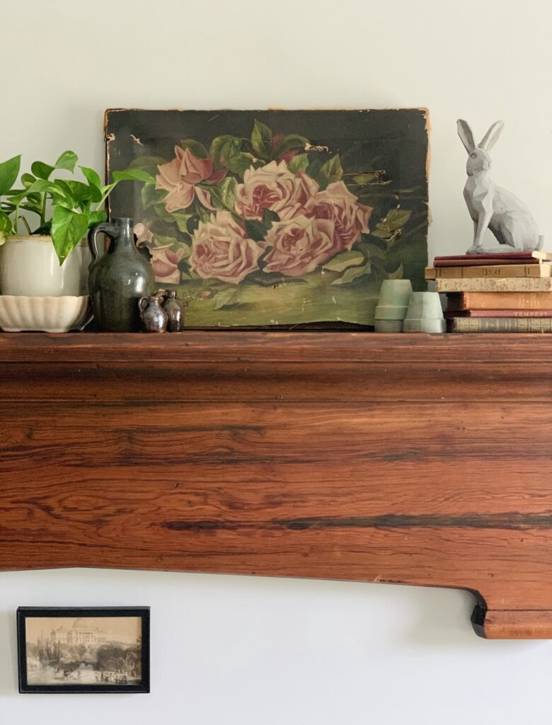 an oil painting that is the focal point of this vintage spring mantel
