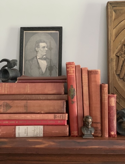a pile of weathered red books on my vintage patriotic mantel