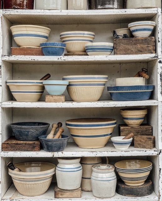 a shelf full of blue bowls