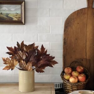 Kitchen Counter Fall Decor including a bread board and some stems