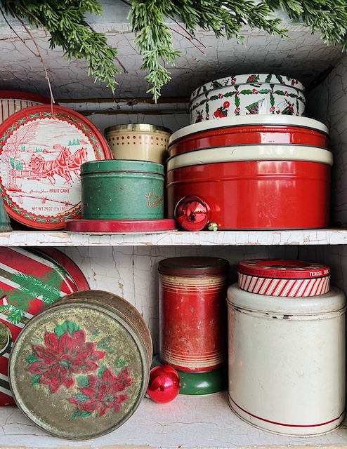 vintage christmas tins on the top two shelves